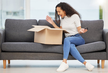 Delivery, woman and unboxing package on sofa for online shopping, shipping or ecommerce in living...