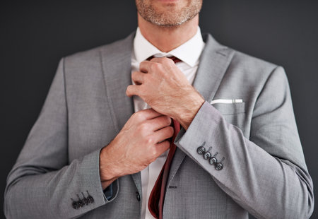 Man, tie and fashion suit in studio, grey background and corporate style. Formal wear, isolated and event attire or broker, success and mature businessman with expensive clothes as professionalの写真素材