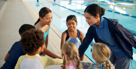 Swimming pool, lesson and teacher with kids in huddle for learning, practice and training. Teamwork, celebrate and swimmer instructor with happy children for exercise, fitness and water sports classの写真素材