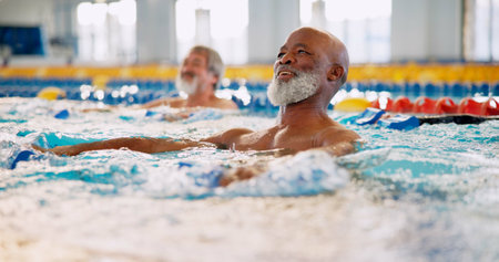 Dumbbell, smile and mature man in swimming pool for exercise, healthy body and strong muscle. Aqua therapy, water and aerobics class for fitness, physiotherapy or rehabilitation of senior peopleの写真素材