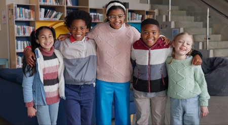 Education, kids and smile in library for portrait, support and diversity in school. Young study group, friends and happy for knowledge with books, growth and english class for language developmentの写真素材
