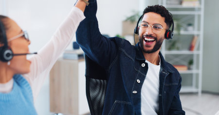 Happy, business people and high five with headset in call center for telecom, motivation and support. CRM, office and agent with celebration for customer service, telemarketing and sale success bonusの写真素材