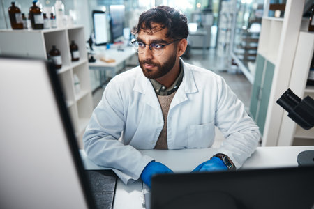 Laptop, medicine and science with man in laboratory for development, innovation or research. Computer, pharmaceuticals and study with serious scientist at work on medical breakthrough or discoveryの写真素材