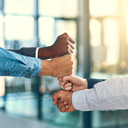 Business people, fist and stack in office for team building, inclusion and equality with motivation...
