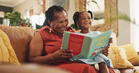 Grandmother, child and laugh with book for education or smile, learning literature and fantasy storytelling. Black family, reading and creative knowledge of support, language growth or care at houseの写真素材
