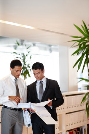 Teamwork, business people and paperwork in office for analysis, reading and compliance for justice. Law firm, men or lawyers with court document for immigration case, collaboration and discussionの写真素材
