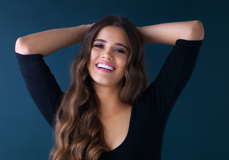 Portrait, hair care and beauty of happy woman with confidence or laugh isolated on studio background. Face, skincare or hairstyle with makeup cosmetics for aesthetic or salon treatment at hairdresserの写真素材