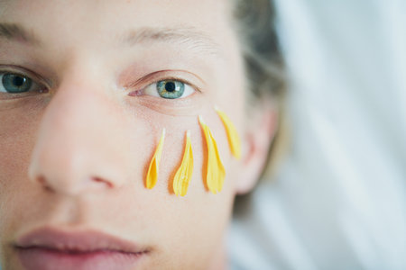Portrait, skincare and woman with flower petals for organic beauty treatment, shine and sustainable dermatology. Face, cosmetics and natural floral plant for glow, benefits and relax at spa closeupの写真素材