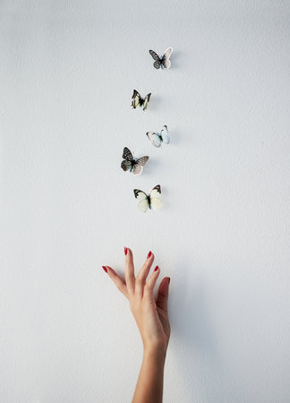 Woman, hand and release butterfly in studio for liberation art, beginning and beauty of freedom or transformation. Mockup space, white background and letting go, metamorphosis and aesthetic change.の写真素材