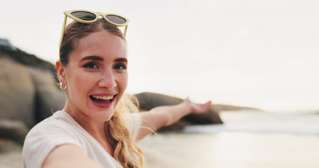Happy woman, portrait and beach with selfie for photography, vlog or memory on vacation in nature. Face of young female person or tourist with smile for picture, moment or sightseeing by ocean coastの写真素材