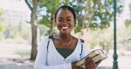Portrait, black woman or student with textbooks in park in university for future or study in college. Face, break or confident African girl in nature with pride for school, education or scholarshipの写真素材