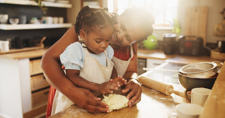 Black woman, child and teaching with dough, cooking and nutrition for support, love and education. Grandmother, girl and baking for development, growth and kitchen as happy family in bonding in homeの写真素材