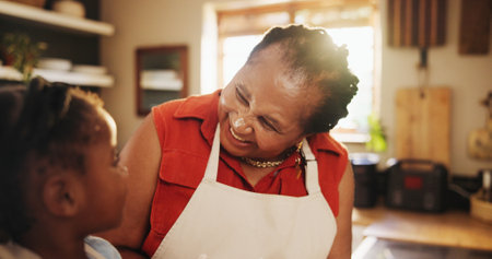 Grandmother, child and teaching with cooking, kitchen counter and learning in home for education, love or care. Black woman, girl and baking in development, growth and nutrition as family in bondingの写真素材