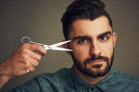 Man, scissors and portrait on studio background, confident and ready for haircut transformation or trim. Male person, grooming tool and care for cosmetics, maintenance and hairstyle change for growthの写真素材