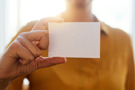 Hand, business person and holding card for advertising service, mockup and space at startup. Closeup, blank paper and worker show promo, marketing information or commercial sign with contact detailsの写真素材