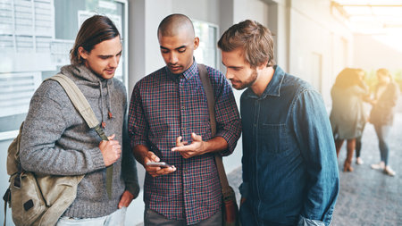 Happy, students and friends with communication or smartphone for networking, social media and academy website. Male people, online and conversation on university campus with diversity and scholarshipの写真素材