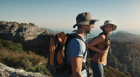 Couple, hiking and mountain on cliff outdoor for fitness travel, adventure view and backpack...