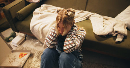 Woman, thinking and stress on floor in home with depression, unemployment and disappointed in living room. Girl, frustrated and hopeless with anxiety, jobless and overwhelmed with failure on top viewの写真素材