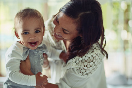 Laugh, mom and baby in home with love, maternal or nurturing care and support for growth or development. Mother, boy toddler and together in family house for bonding, emotional connection or wellnessの写真素材