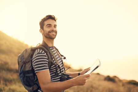 Hiker, man and travel with adventure, map and getaway trip with smile, location and nature. Direction, happy person and tourist with destination, fitness and hobby for health, hiking and journeyの写真素材