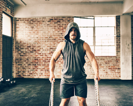 Man, portrait and rope for fitness at gym for bodybuilding with strength and determination. Male person, muscles and strong on training, workout and exercise for health and self care as bodybuilderの写真素材