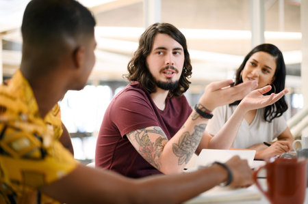 Collaboration, ideas and team director planning project with coffee, discussion and research. Teamwork, diversity and happy business people for creative, working and presentation in meeting in officeの写真素材