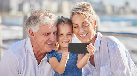 Smile, grandparents and child with selfie for travel, vacation and document memories with photography. Outdoor, grandmother and grandfather with girl in Sydney for picture, social media and bondingの写真素材
