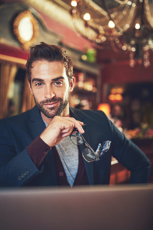 Pub, man and portrait with confidence in fancy bars, restaurant and smile ready for date. Fashion, glasses and trendy male person from Italy with flirt, nightlife and happy waiting for dinnerの写真素材