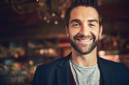 Smile, confidence and portrait of man in pub with weekend culture, social networking and fun. Gentleman, face and manager at trendy bar in nightclub with pride for cool fashion and happy hourの写真素材