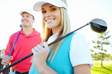 Golf, woman and happy couple with club for sport or game with wood driver in nature. Golfers course, man and partner smile outdoor for exercise, training or competition practice for fitness togetherの写真素材