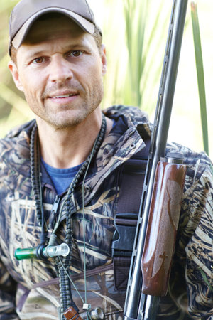 Man, portrait and rifle with gear outdoor for camouflage, hunting wildlife or adventure activity of...