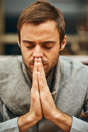 Student, praying and spiritual in university for learning, worship and college scholarship in library. Man, study and meditation to God on campus for school project, education and final exam or testの写真素材