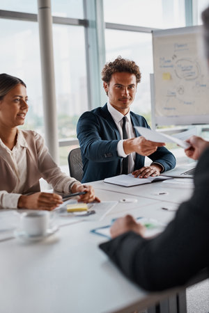Business, people and meeting with documents at boardroom for strategy and brainstorming. office, employees and planning with ideas for project with teamwork, collaboration and discussion for growthの写真素材