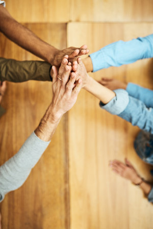 Above, students and high five for teamwork at library for education with unity, support and trust. University project, people and hands together for collaboration on group work for assignmentの写真素材