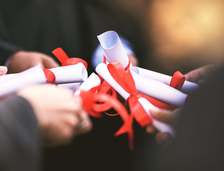 Graduation, diploma and hands of team for celebration, award or learning milestone. People, group...