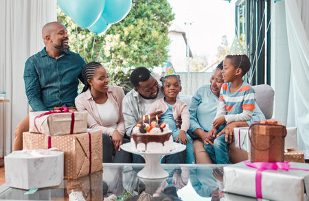 Birthday cake, gifts and portrait of black child with family at party with balloons for celebration at home. Happy, presents and girl with dessert for event with grandparents, parents and brother.の写真素材