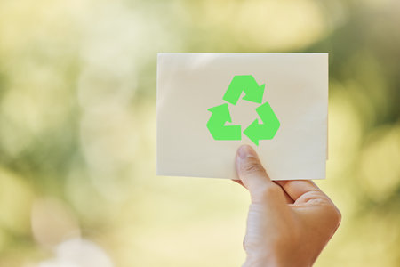 Recycle, logo and hand of person in nature with sign for sustainability, waste management and forest care. Park, planet and volunteer with green arrow icon for climate change, pollution or spaceの写真素材