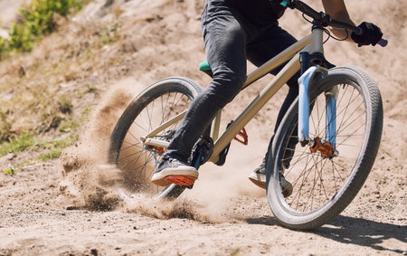 Action, sand and person on bicycle for riding, fitness and exercise outdoor with race, speed or dirt. Athlete, performance and off road mountain bike cycling for adventure, sport or workout in natureの写真素材