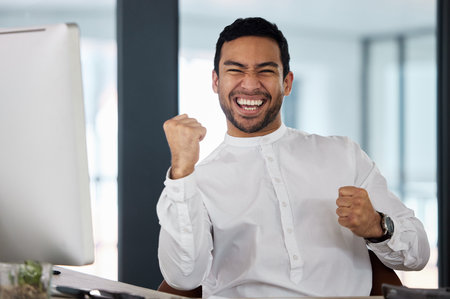 Fist pump, winner and portrait of businessman on computer for online bonus, stock market and promotion. Corporate worker, office and happy person celebrate for investment, profit and opportunityの写真素材