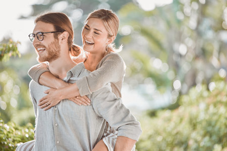 Couple, smile and piggy back in garden with game, bonding and playful outdoor in spring for...