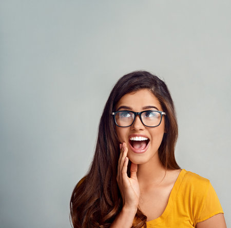 Woman, thinking and planning in studio for idea, problem solving and solution with mockup space. Female person, editor and glasses on white background for decision, vision and creative inspirationの写真素材