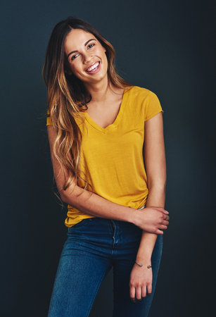 Fashion, woman and studio portrait with denim, happiness and smile for style or t shirt. Confident, student or gen z and makeup or clothes by black background with pride, trendy outfit and aestheticの写真素材