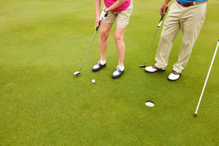 Outdoor, golf club and legs on green for tee off in team as members in course for health, wellness...