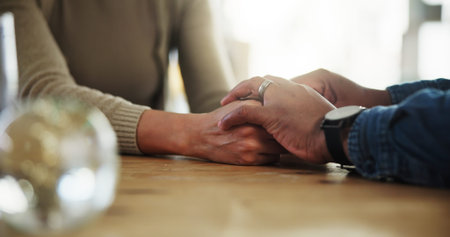 Holding hands, couple and support on table, home and promise of love, compassion and communication....