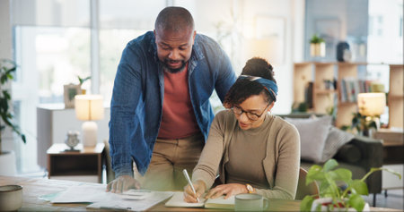 Financial paperwork, writing or African couple with planning or household budget in home. Bills, calculate or people filling form documents for accounting report of investment growth, taxes or salaryの写真素材