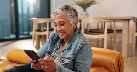 Mature, woman and typing on sofa with phone for text message, communication or dating site in home....
