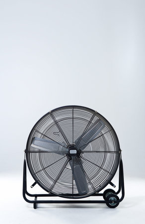 Large, metallic fan and electric appliance with blades, steel and industry on gray studio...