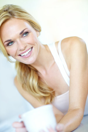 Thinking, house and woman with coffee, smile and weekend break with morning routine, calm and joy. Person, apartment and girl with espresso, happiness and cappuccino in living room, comfort and peaceの写真素材