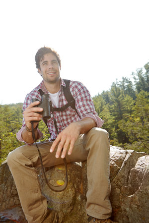 Binoculars, forest and man hiking for journey, jungle adventure and nature explore with backpack. Hiker, camper and guy trekking in woods for view, search or birdwatching outdoor Norway travelの写真素材