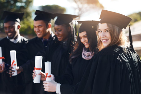 Certificate, college and portrait of students at graduation celebration with smile, achievement and education. University, women and men on campus with diploma, diversity or friends at award ceremonyの写真素材